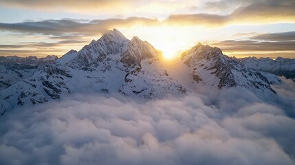 A stunning aerial view of snow-covered mountain peaks rising above a sea of clouds at sunset. The sun is setting behind the mountains.