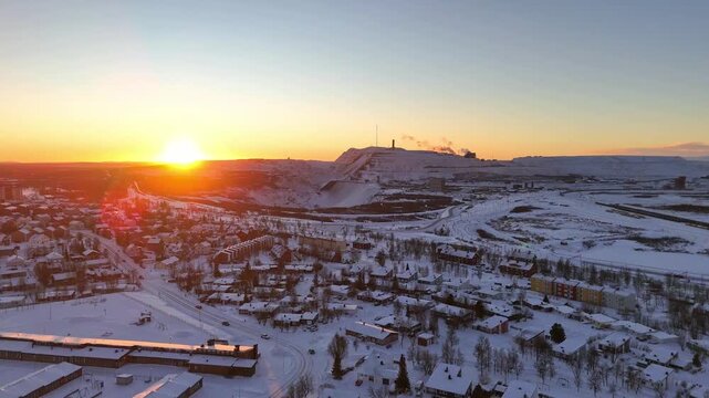 Kiruna, Sweden, aerial descending view over the city and the iron ore mine, during high noon just before the polar night sets it. Winter, snow, ice, clear sky