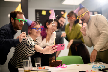 Friends celebrate a birthday with funny glasses and a cake during a lively gathering in an office setting