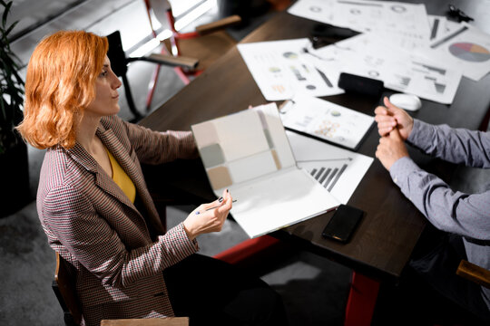 Business meeting between two professionals discussing project ideas in a modern office space during daytime