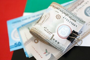 United Arab Emirates dirham currency money bills lies on flag close up. The concept of business and investment