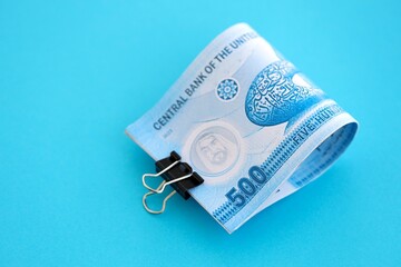 United Arab Emirates dirham money bills in big amount on blue close up. Finance and banking concept