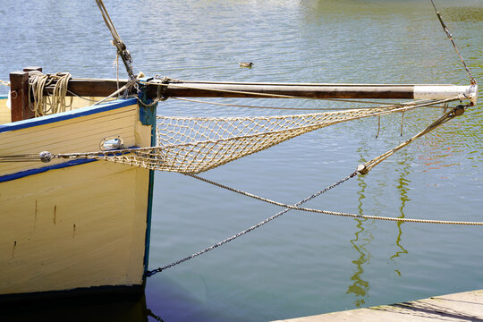 ship bow of a traditional wooden boat with a netting over calm water