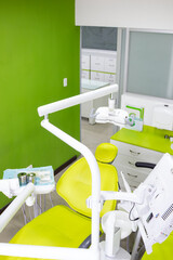 Modern dental clinic interior with green walls and chair