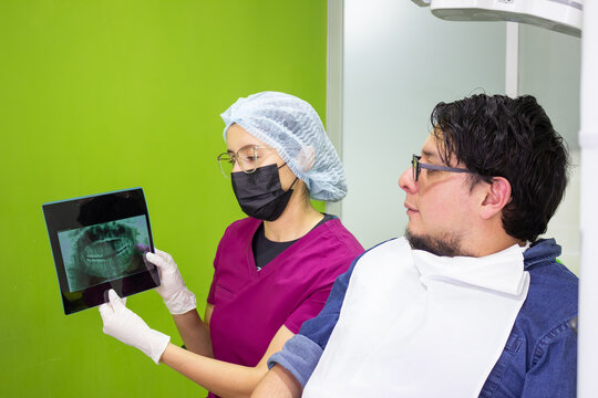 Dentist discussing panoramic x-ray with patient in clinic