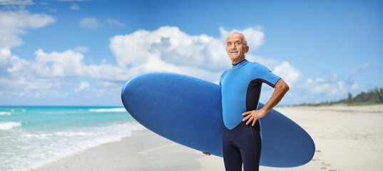 Elderly man in a wetsuit on a sandy beach