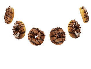 A variety of chocolate drizzled donuts are displayed in a fun, scattered arrangement. The donuts feature rich frosting and chocolate sprinkles, creating an inviting treat.