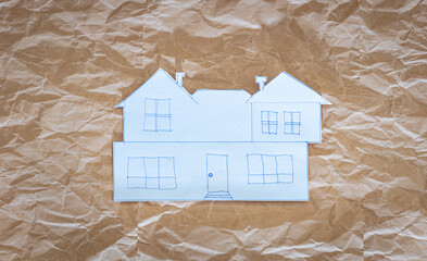 Paper house sketch on crumpled kraft paper background, creative architectural concept