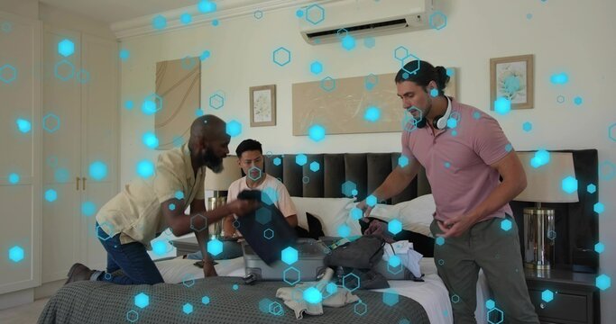 Packing group of five men sorting suitcases on hotel room bed with gray bedspread, polo, headphones