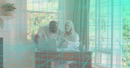 Reviewing couple in light shirts, pointing at laptop at dining nook with papers and teal grid