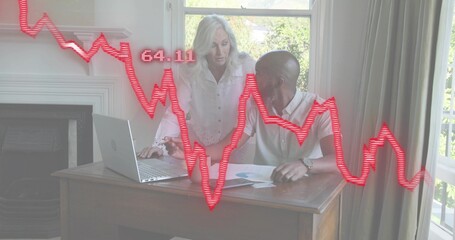 Pointing woman in white blouse leaning over desk at home, man reviewing laptop, red graph 64