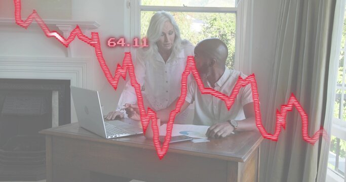 Pointing woman in white blouse leaning over desk at home, man reviewing laptop, red graph 64
