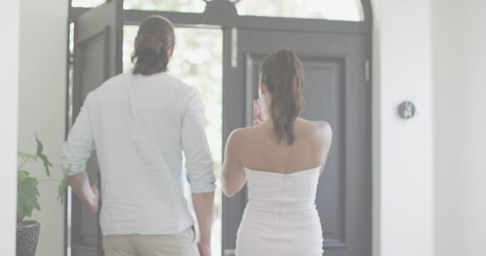 Standing man in rolled sleeves and woman in strapless holding smartphone at entry with transom - Powered by Adobe
