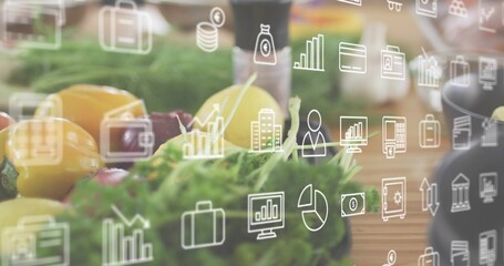 Displaying yellow red bell peppers, lettuce and lemon blending with finance icons on wood counter