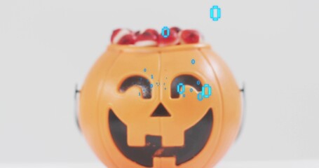 Displaying orange jack-o'-lantern bucket holding red candy on white tabletop, showing cyan overlay