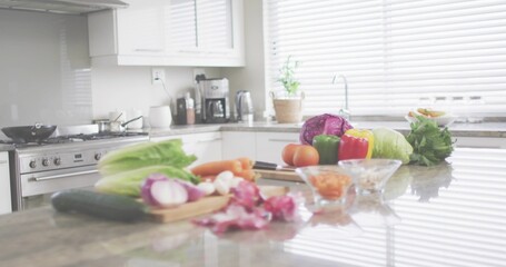 Showcasing center cluster of fresh veggies with cutting board, chef knife on polished stone counter