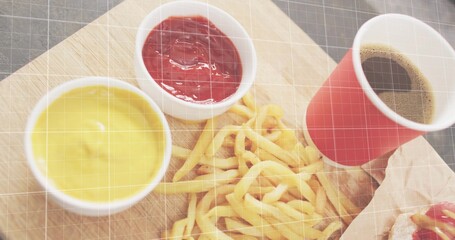 Displaying centered pile of thin French fries on restaurant table, with white ramekins and red cup