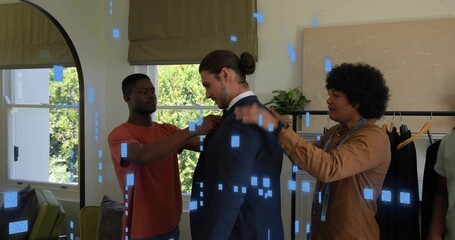 Adjusting assistants fixing jacket and collar on client at home, with dark suit and tape measure