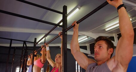 Pulling man gripping bar at gym, metal rig, wearing gray sleeveless top, wristwatch, copy space