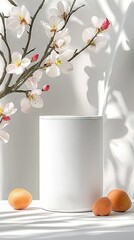A white cylindrical product display is surrounded by apricots and a blossoming branch. The scene is lit by bright sunlight creating shadows on a white backgroun