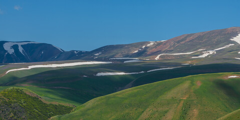 Obraz premium Picturesque hills with remnants of snow on the high-mountain Asy plateau in the Almaty region of southeastern Kazakhstan on a spring morning
