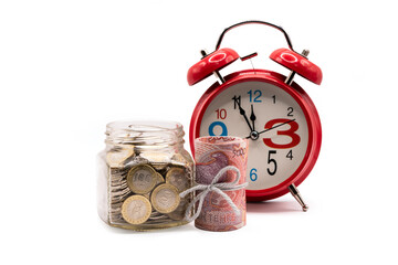 5,000 Kazakhstani tenge banknotes and a glass jar with 100 tenge coins on a white background