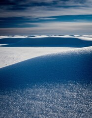 Serene Winter Landscape with Snow-Covered Rolling Hills and Skies