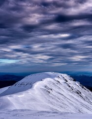 Majestic Snow-Capped Mountain Ridge Under Dramatic Cloudy Sky