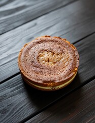 Round Layered Cake with Golden Brown Texture on Dark Wooden Surface