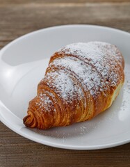 Flaky Croissant Dusting Powdered Sugar on White Plate for Breakfast