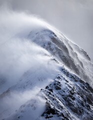 Dramatic Snowy Mountain Peaks with Wind Blowing Snow and Clouds