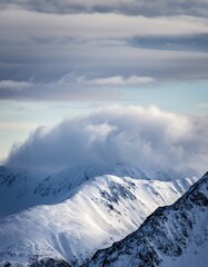Serene Snow-Covered Mountains Under Soft Cloudy Sky at Dusk