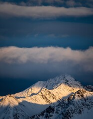 Majestic Snow-Capped Mountain Peaks Under Dramatic Cloudy Sky