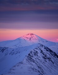 Serene Mountain Landscape with Sunset Glow Over Snowy Peaks