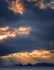 Dramatic Sunset with Dark Clouds and Rays of Light Over Landscape