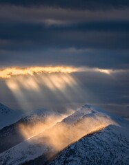 Majestic Mountain Landscape with Sunlight Breaking Through Clouds