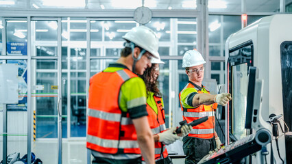 Three engineers program an industrial robot or 5-axis CNC machine using an AI interface. The team manufactures advanced microchips or high-tech components in a smart factory.