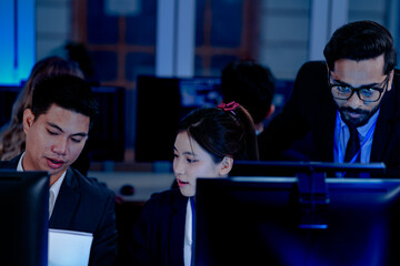 Deep dive into the code  Software engineers review system architecture or debug complex scripts together. Analyzing performance metrics on multiple screens in a dev hub at night.