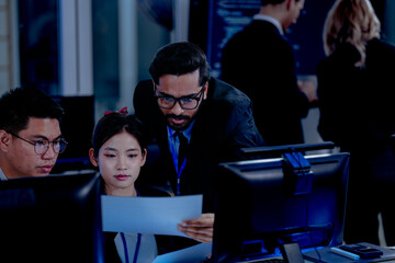 Critical AI model review. Senior data scientist leans over analyzing code output with junior engineers. Debugging complex algorithms together for optimal service performance at night.