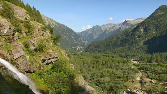 Alpine valley seen from above, with a waterfall on the left. Summer landscape of the Anzasca valley and of the Macugnaga at the foot of Monte Rosa, Piedmont region, Italy