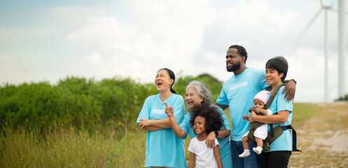 Group portrait Volunteers are walking behind a windmill farm, volunteer charity people. charity community service event, ngo business and outreach, Group Diverse people meeting at park for donation