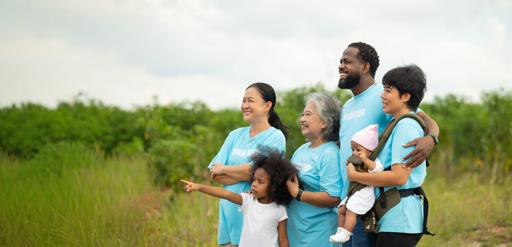 Group portrait Volunteers are walking behind a windmill farm, volunteer charity people. charity community service event, ngo business and outreach, Group Diverse people meeting at park for donation - Powered by Adobe