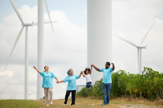 Volunteers are walking behind a windmill farm, volunteer charity people. charity community service event, ngo business and outreach, Group Diverse people meeting at park for donation - Powered by Adobe