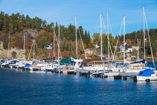 A peaceful Norwegian harbor with sailboats moored at a marina - Powered by Adobe