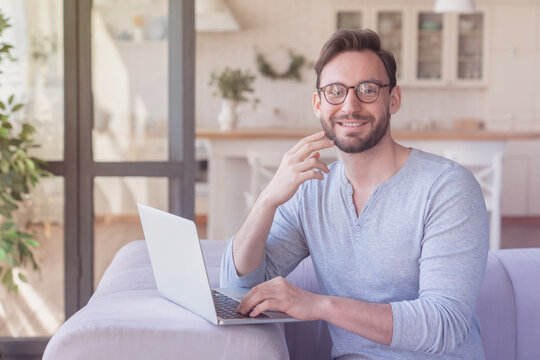 Confident caucasian young man businessman freelancer entrepreneur investor trader using laptop, working at home, home office, doing online shopping, checking email, typing indoors. Remote work concept - Powered by Adobe