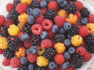 Freshly picked assorted berries create a vibrant colorful mix perfect for a healthy snack or baking project, blueberries, raspberries, golden berries