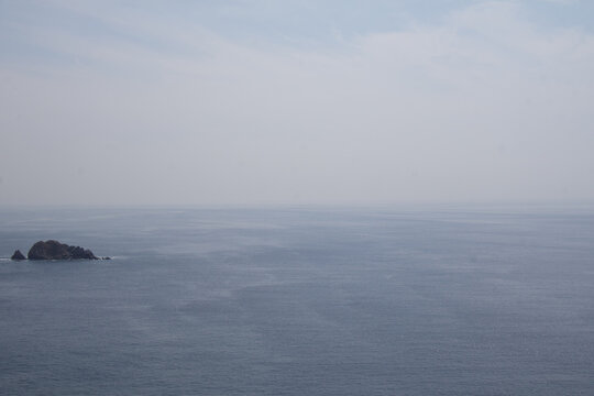 Minimal ocean horizon with rock in calm sea - Powered by Adobe