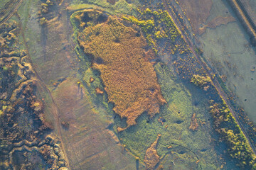 Top-down aerial view of military defensive positions and zigzagging trenches cleverly concealed by dense vegetation in a combat zone.