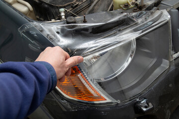 Polishing the old headlight on the car and installing a protective film