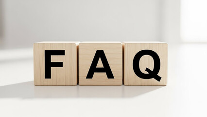 Three wooden blocks displaying the letters f a q in black against a white background surface area